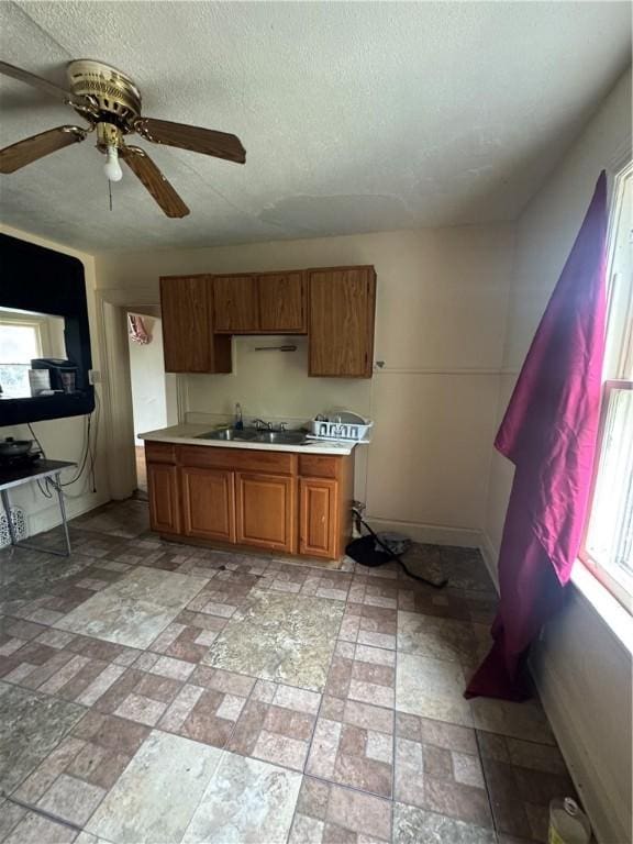 408 Glenwood Ave, Rochester, NY 14613 - kitchen with a sink, light countertops, brown cabinets, healthy amount of natural light, and a textured ceiling