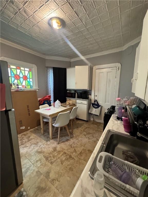 408 Glenwood Ave, Rochester, NY 14613 - kitchen with crown molding, freestanding refrigerator, white cabinetry, and light countertops