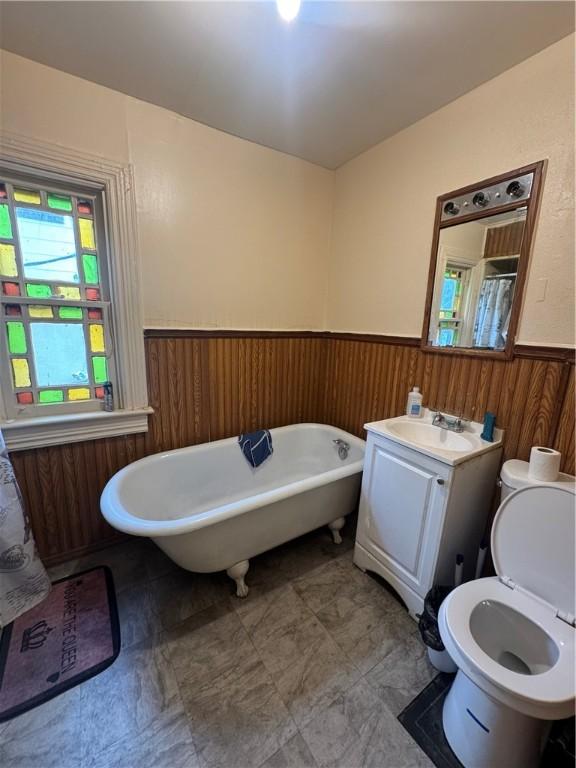 408 Glenwood Ave, Rochester, NY 14613 - full bath with wainscoting, a freestanding bath, toilet, vanity, and wood walls