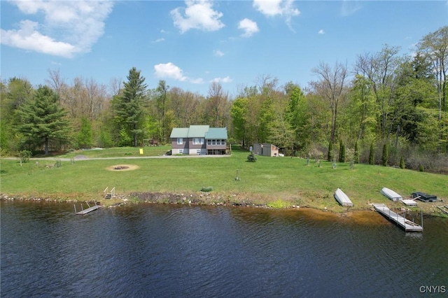 dock with a water view, a yard, and a fire pit