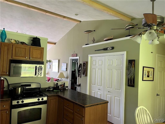 kitchen featuring stainless steel appliances, dark countertops, ceiling fan, a peninsula, and brown cabinetry
