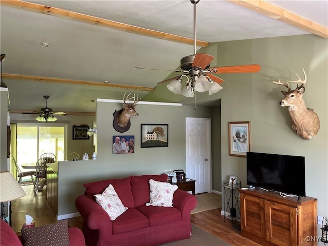 living area with a ceiling fan, wood finished floors, and baseboards