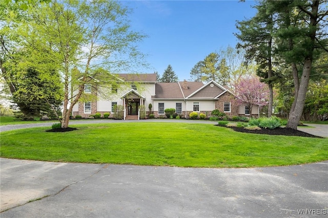 view of front facade with a front lawn and curved driveway