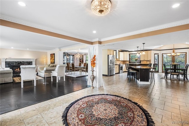 living area featuring a chandelier, a high end fireplace, crown molding, recessed lighting, and stone tile flooring