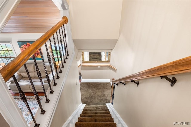 stairway featuring carpet floors and baseboards
