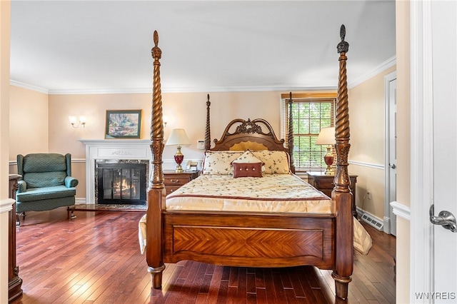 bedroom with wood-type flooring, ornamental molding, and a fireplace with flush hearth
