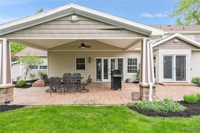 rear view of property featuring a patio area, a ceiling fan, and a yard