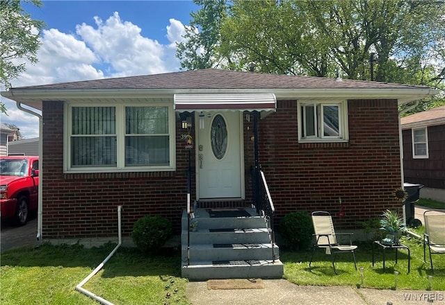 397 Broad St, Tonawanda-City, NY 14150 - view of front of home featuring brick siding, a front yard, and a shingled roof