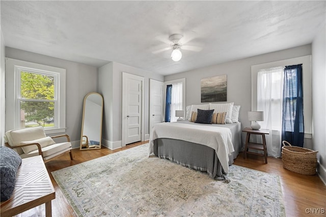 bedroom with wood finished floors, baseboards, and ceiling fan