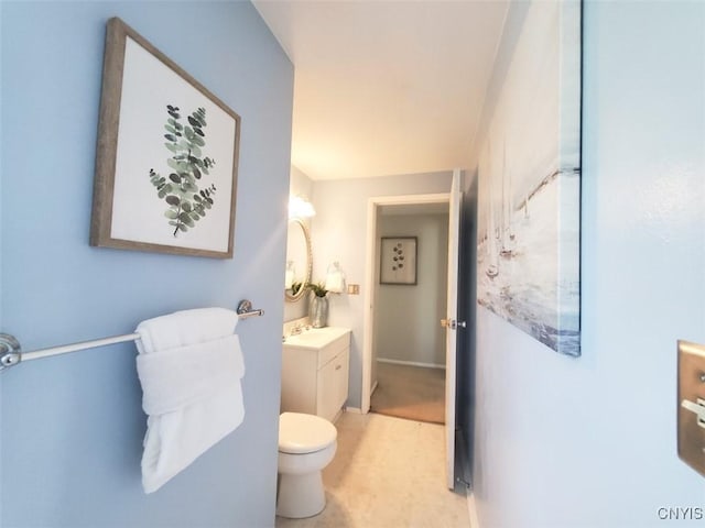 bathroom with vanity, toilet, and baseboards