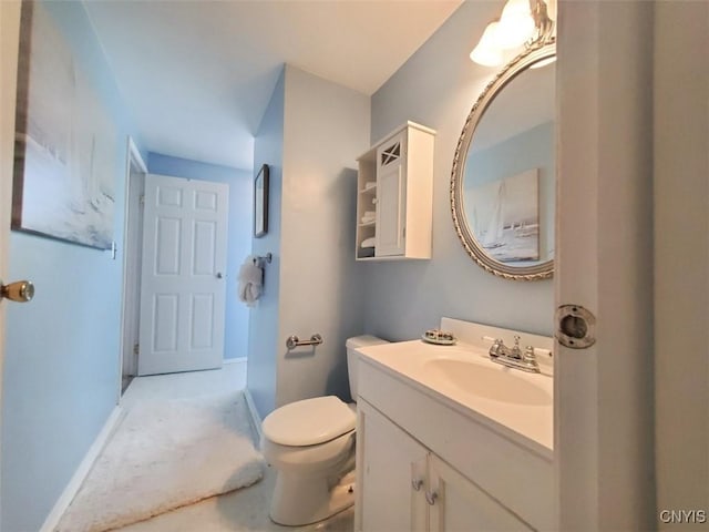 bathroom featuring vanity, toilet, and baseboards