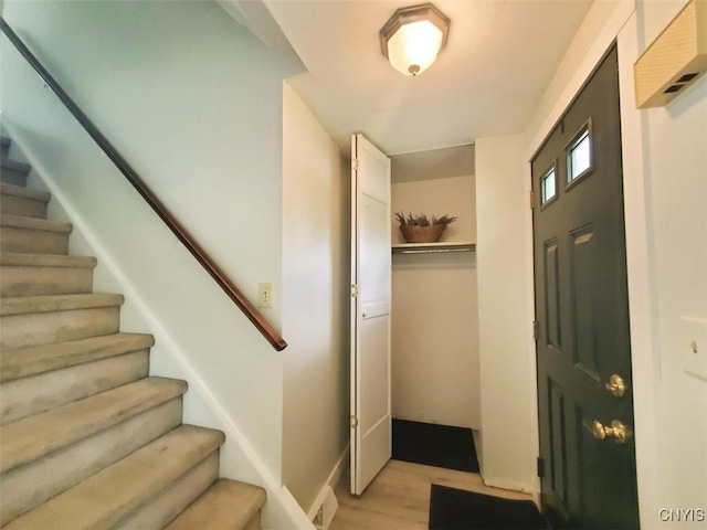 foyer entrance featuring stairs and light wood finished floors