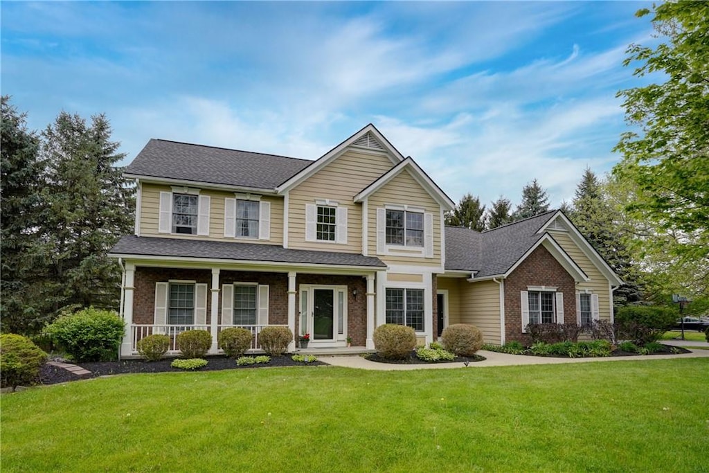 1001 Hickory Holw, Webster, NY 14580 - traditional-style house with brick siding, a front yard, and covered porch