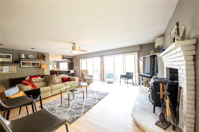 1177 County Highway 26, Otsego, NY 13337 - living room with a wall mounted AC, a ceiling fan, a fireplace, and wood finished floors