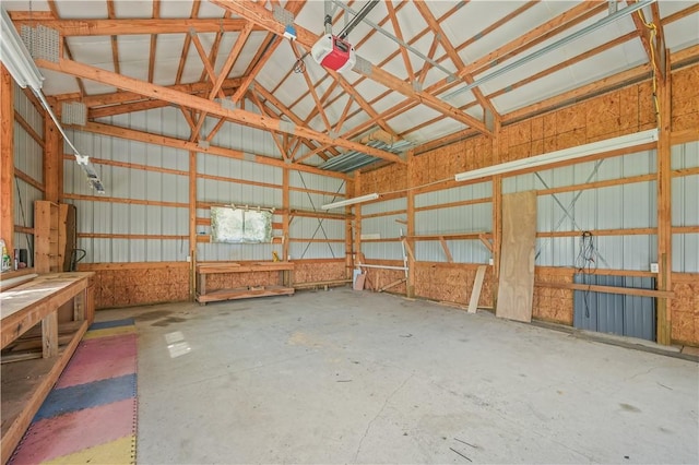 725 Arabia Rd, Summit, NY 12175 - miscellaneous room featuring vaulted ceiling, a garage, metal wall, and unfinished concrete floors
