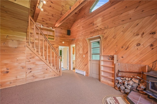725 Arabia Rd, Summit, NY 12175 - unfurnished living room with stairs, wood walls, a wood stove, carpet, and high vaulted ceiling