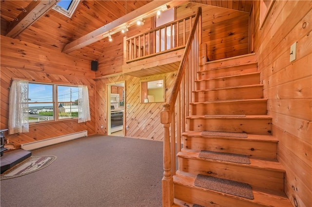 725 Arabia Rd, Summit, NY 12175 - stairs featuring a baseboard heating unit, rail lighting, wooden walls, a wood stove, and carpet floors