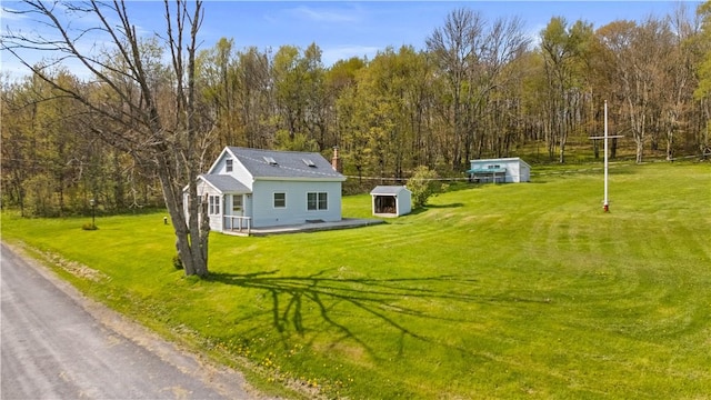725 Arabia Rd, Summit, NY 12175 - view of front of property with an outdoor structure, a front yard, a wooded view, and a storage unit