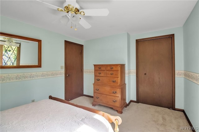 bedroom featuring light colored carpet, a closet, ceiling fan, and baseboards