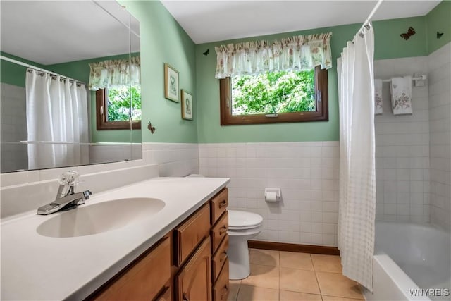 bathroom with plenty of natural light, tile walls, toilet, tile patterned flooring, and vanity