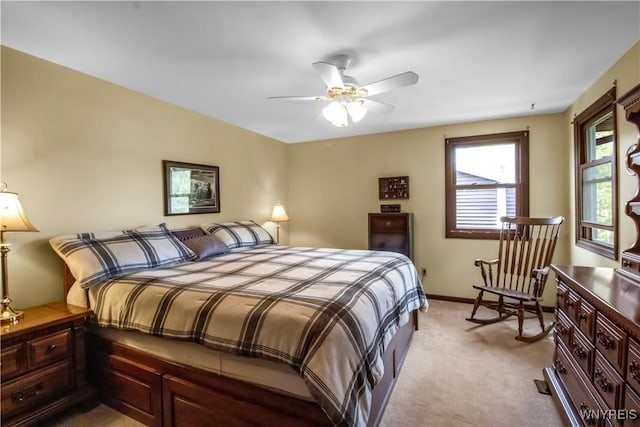 bedroom featuring light carpet, baseboards, and a ceiling fan