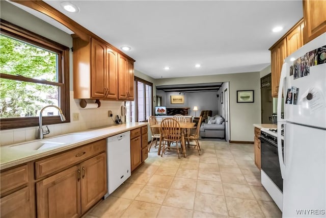 kitchen featuring white appliances, a sink, light countertops, decorative backsplash, and recessed lighting