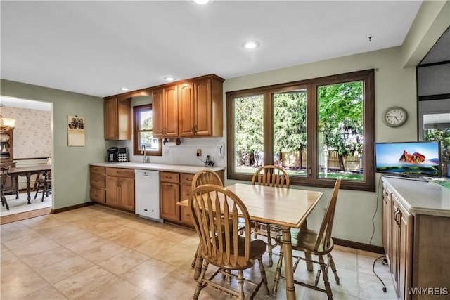 kitchen with white dishwasher, light countertops, brown cabinets, tasteful backsplash, and recessed lighting