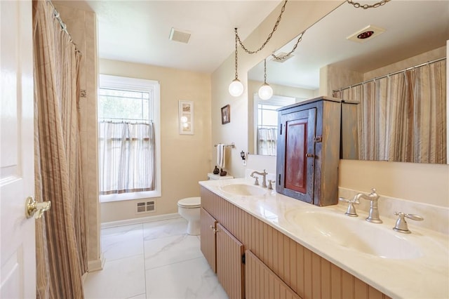 bathroom featuring marble look tiles, toilet, double vanity, and baseboards