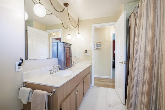 full bathroom featuring double vanity, baseboards, and tile patterned floors