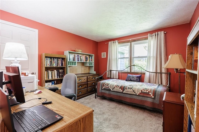 carpeted bedroom with an office area and a textured ceiling