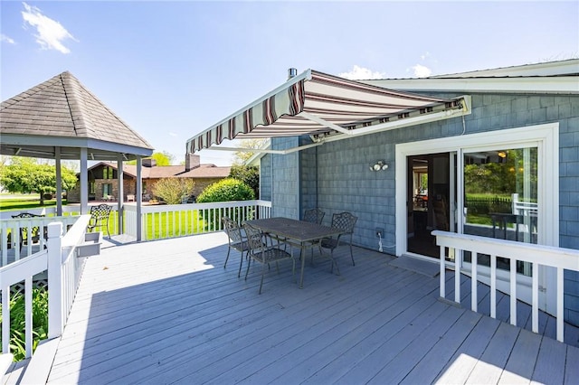 wooden deck with outdoor dining area and a gazebo