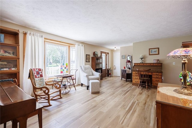 living room featuring a textured ceiling and light wood-style floors