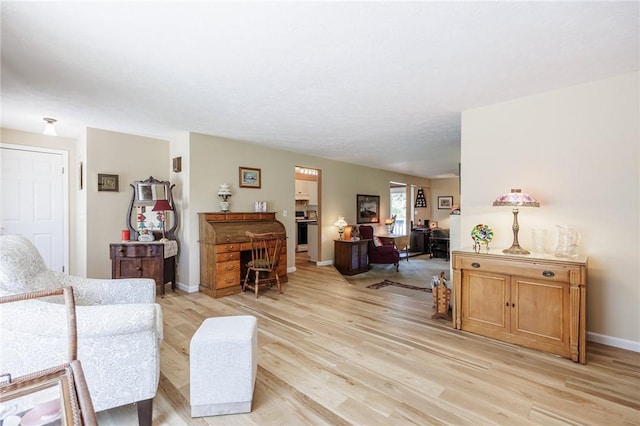 living area featuring light wood-style floors and baseboards