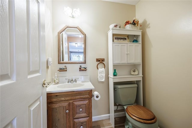bathroom featuring toilet, vanity, and baseboards