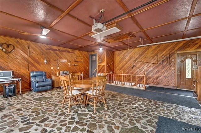 9811 Deer Creek Rd, Genesee, NY 14770 - dining area with stone flooring, wood walls, and a ceiling fan