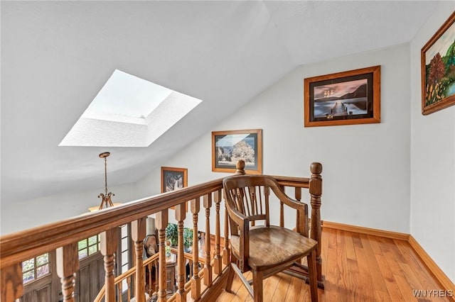 9811 Deer Creek Rd, Genesee, NY 14770 - corridor featuring a skylight, lofted ceiling, light wood-type flooring, an upstairs landing, and baseboards