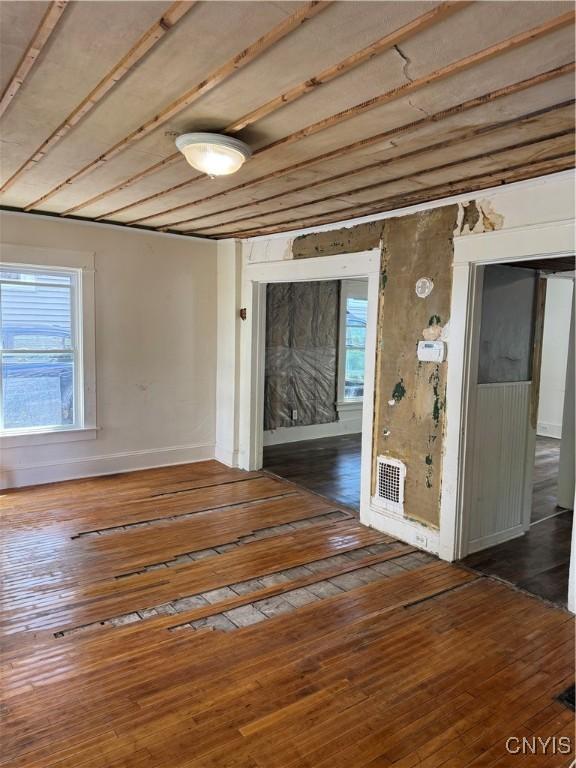 unfurnished room with hardwood / wood-style floors and baseboards