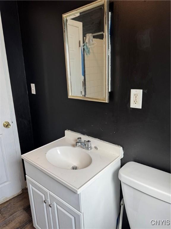bathroom featuring vanity, toilet, and wood finished floors