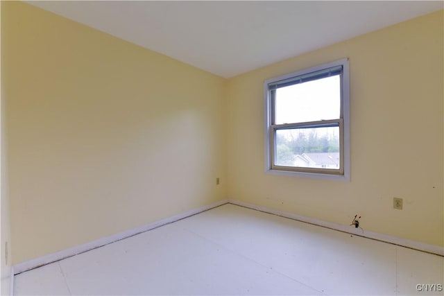 spare room featuring baseboards and finished concrete floors