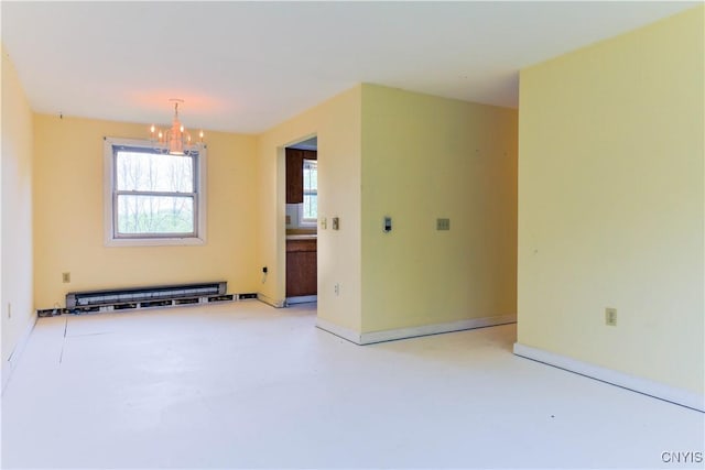 empty room featuring a chandelier, baseboard heating, baseboards, and concrete flooring