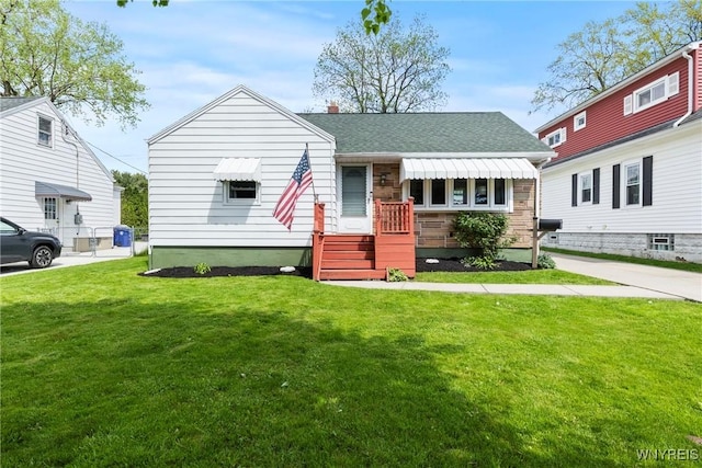 view of front of house featuring a front yard and roof with shingles