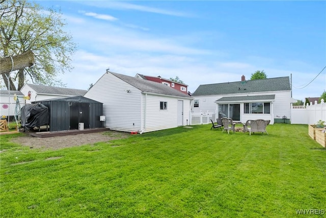 back of property featuring a sunroom and an outbuilding