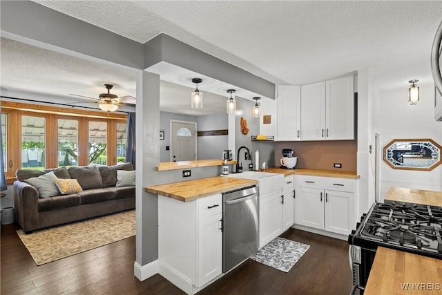 kitchen with stainless steel dishwasher, butcher block counters, range with gas cooktop, dark wood-style flooring, and a textured ceiling