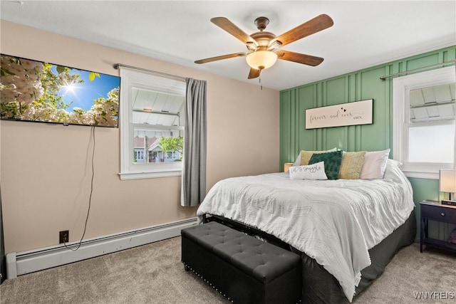 carpeted bedroom with a baseboard radiator and a ceiling fan