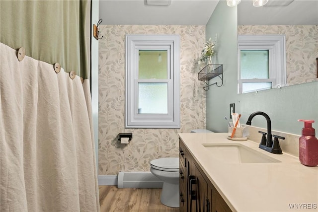 full bath featuring wallpapered walls, wood finished floors, toilet, vanity, and a baseboard heating unit