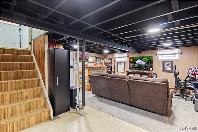 living area with stairs and wood walls