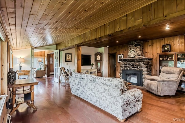 174 Camp Rd, Litchfield, NY 13322 - living area featuring wood walls, wooden ceiling, a stone fireplace, wood finished floors, and a baseboard heating unit