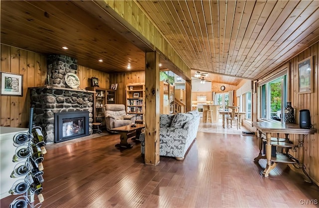 174 Camp Rd, Litchfield, NY 13322 - living area with wooden walls, wood ceiling, hardwood / wood-style flooring, a fireplace, and lofted ceiling