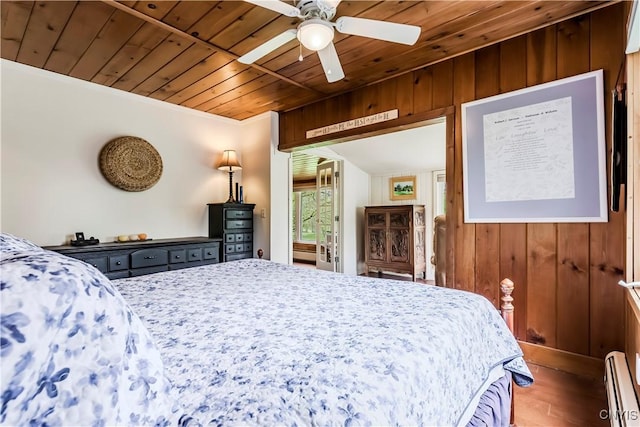 174 Camp Rd, Litchfield, NY 13322 - bedroom featuring wood ceiling, a baseboard heating unit, wooden walls, wood finished floors, and crown molding
