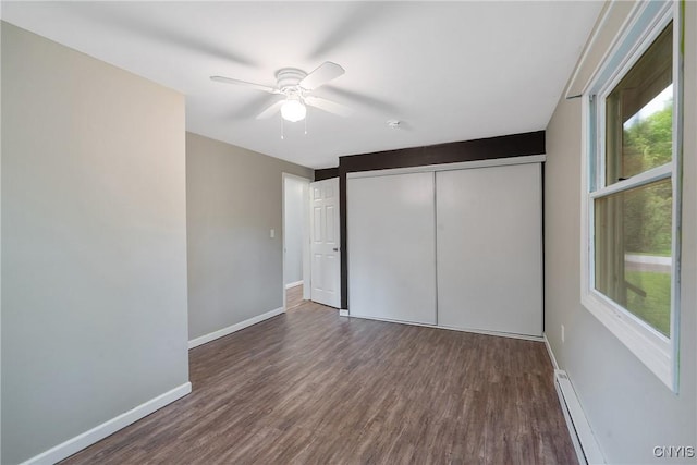 unfurnished bedroom with wood finished floors, multiple windows, a closet, and baseboards